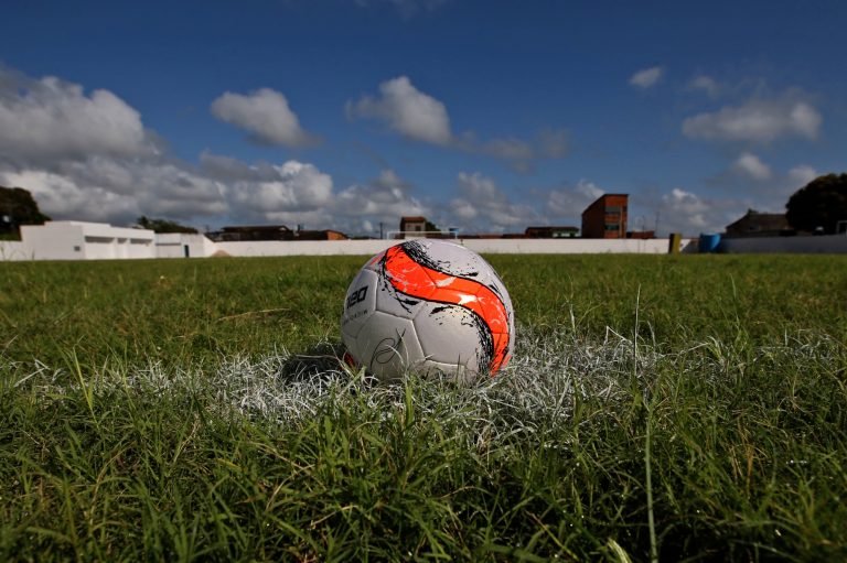 Uma bola de futebol num gramado num dia de sol