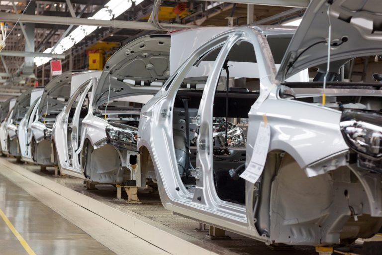 Carros sendo montados em uma fábrica