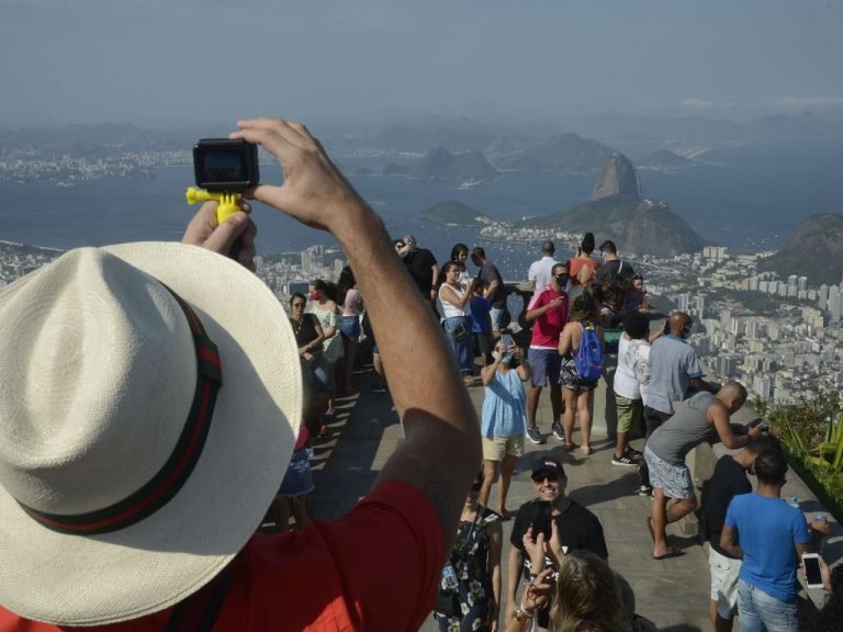 Turista tira foto do alto de um morro