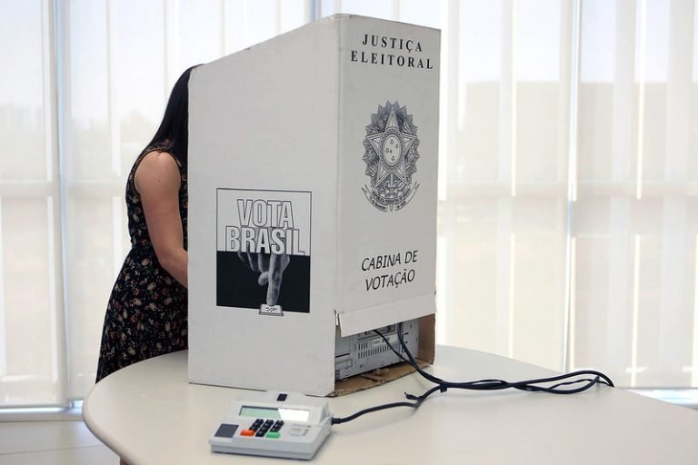 Mulher vota numa urna eletrônica