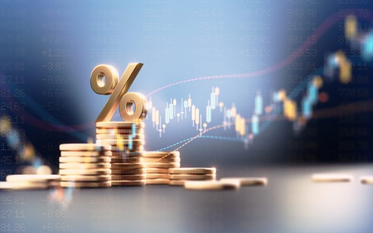 Pilha de moedas com um símbolo de percentual em cima delas