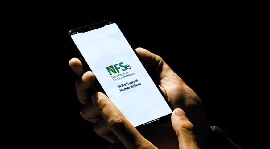 Mão cegura celular aberto no aplicativo da Nota Fiscal Eletrônica