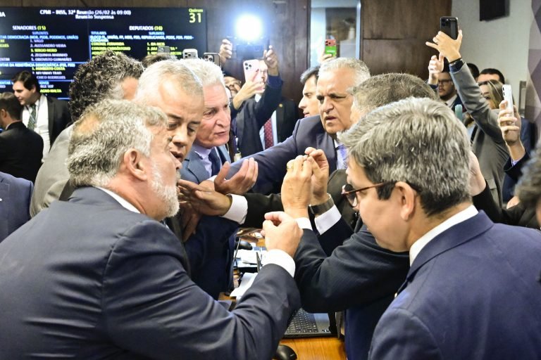 cpmi do inss Parlamentares governistas se aproximam da mesa diretora para protestar após resultado da votação.