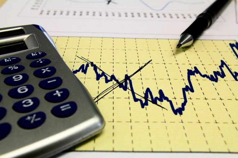 Um gráfico e uma caneta e uma calculadora